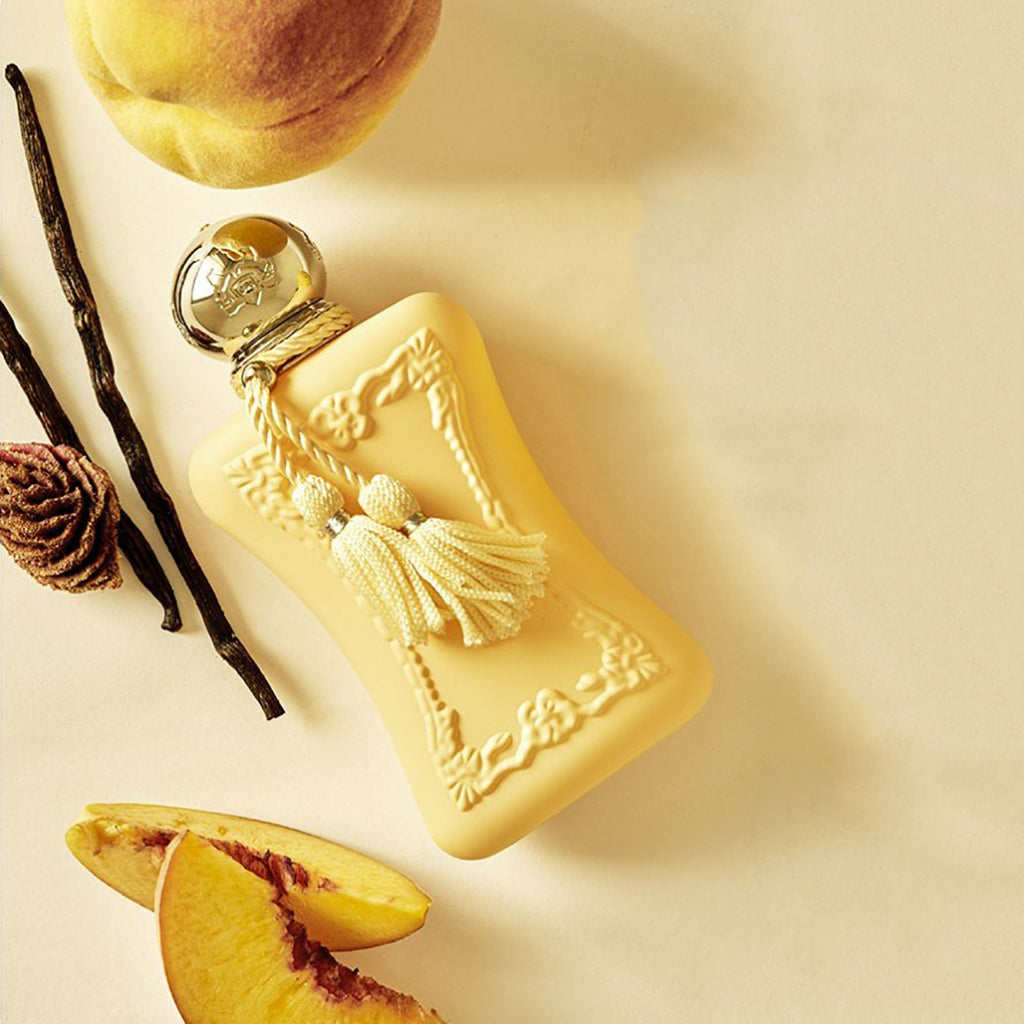 Cassili by Parfums de Marly, 75ml peach bottle with peaches and vanilla flowers in background