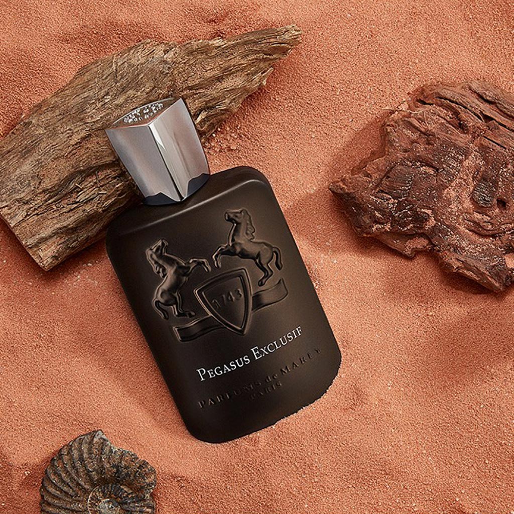 Pegasus Exclusif by Parfums de Marly, 125ml dark metallic bottle displayed on a rustic brown fabric with wooden accents