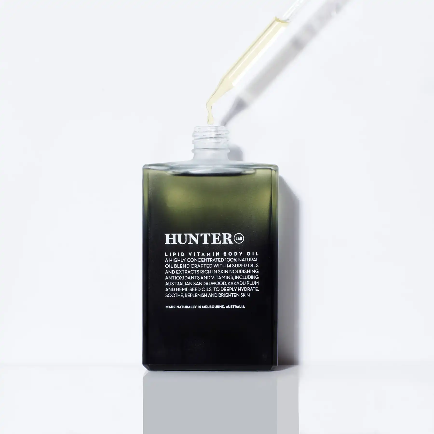 Hunter Lab Lipid Vitamin Body Oil being dispensed with dropper