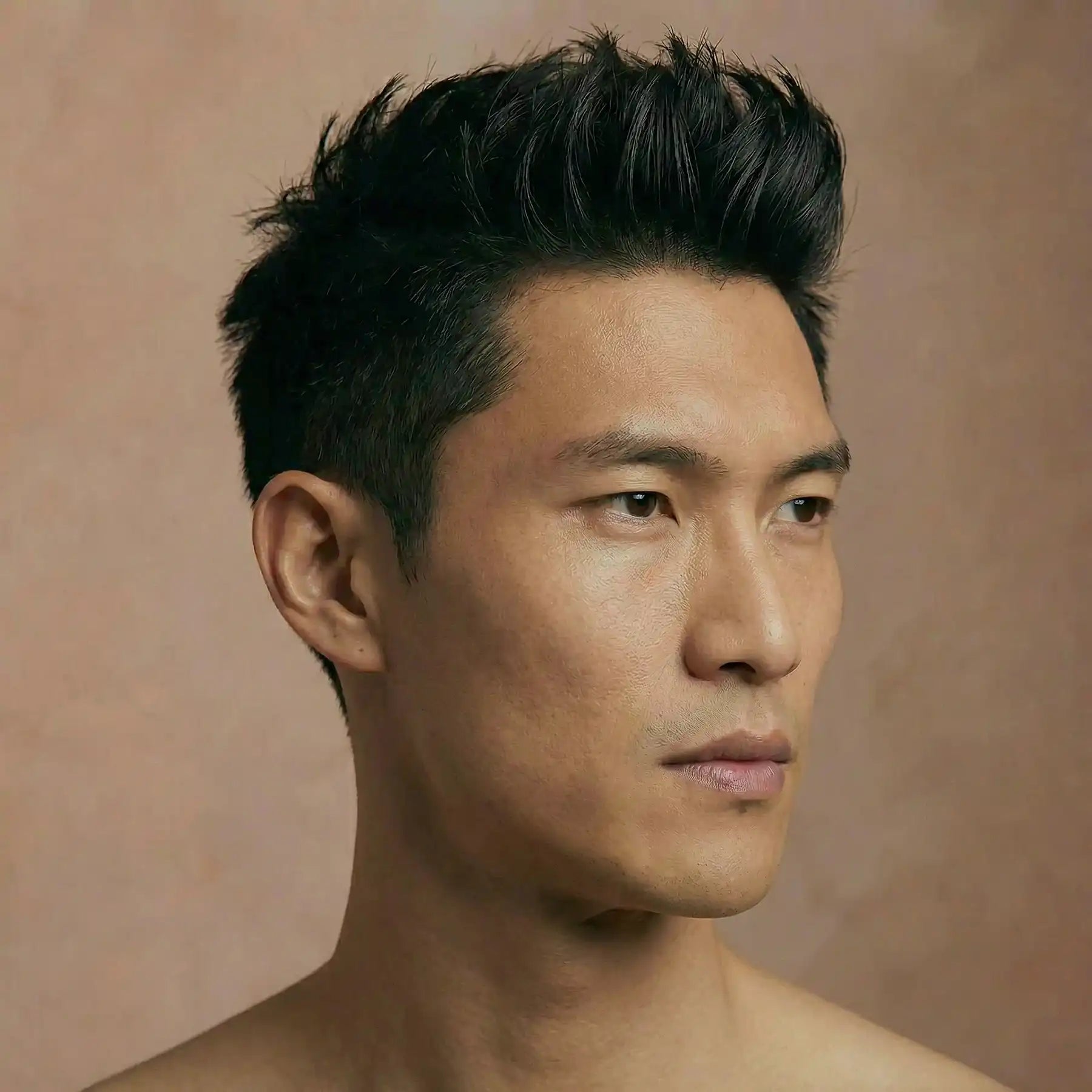 Asian man with fine hair styled using matte balm showing lifted volume and natural texture