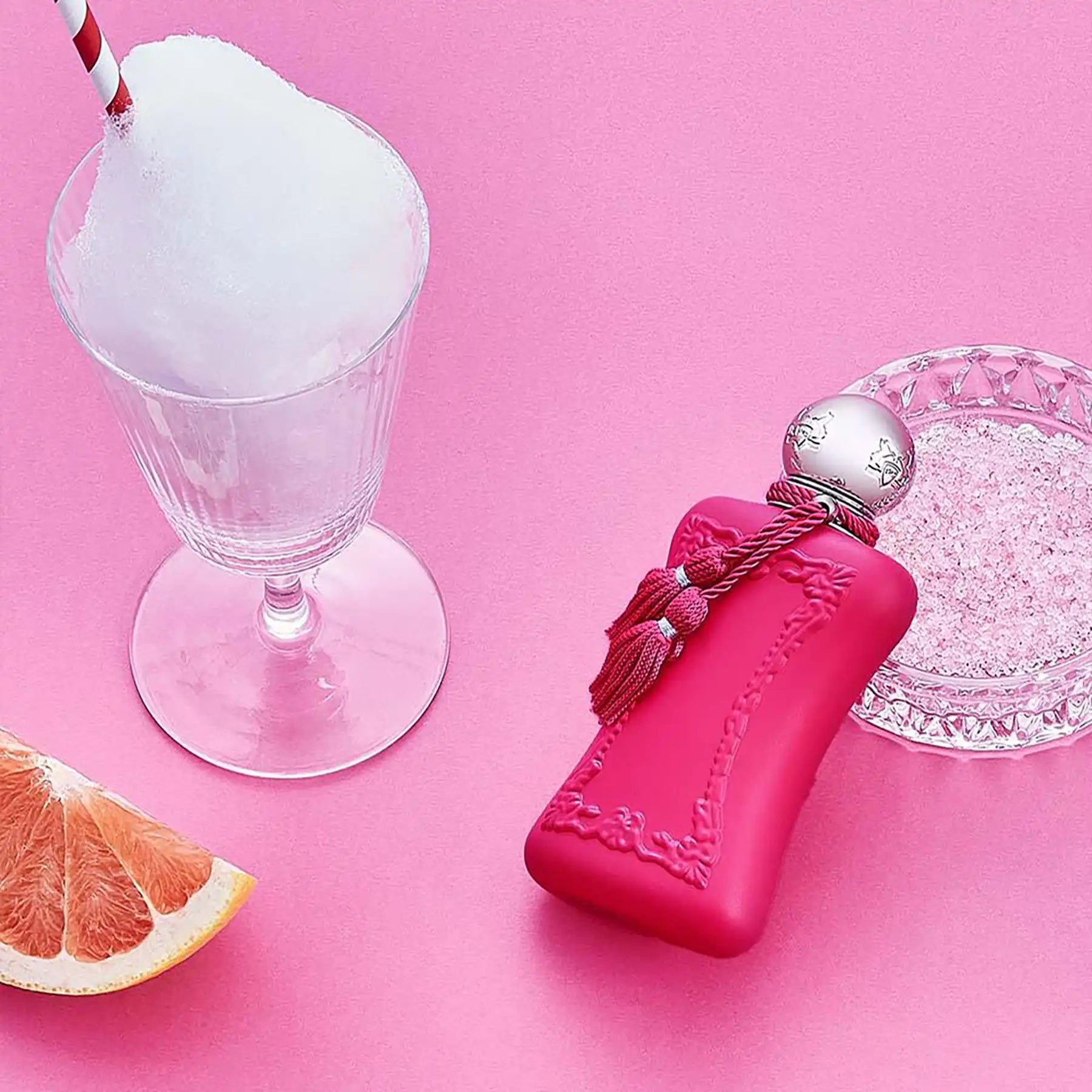 Oriana by Parfums de Marly, pink bottle on a pink background with grapefruit slice and glass ornament