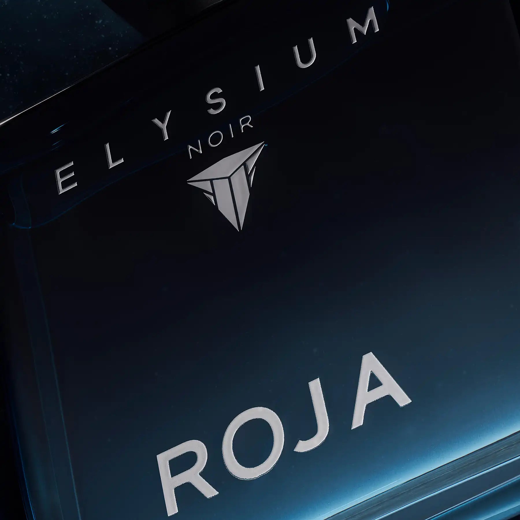 Close-up of Roja Elysium Noir bottle featuring silver embossed lettering and geometric brand emblem