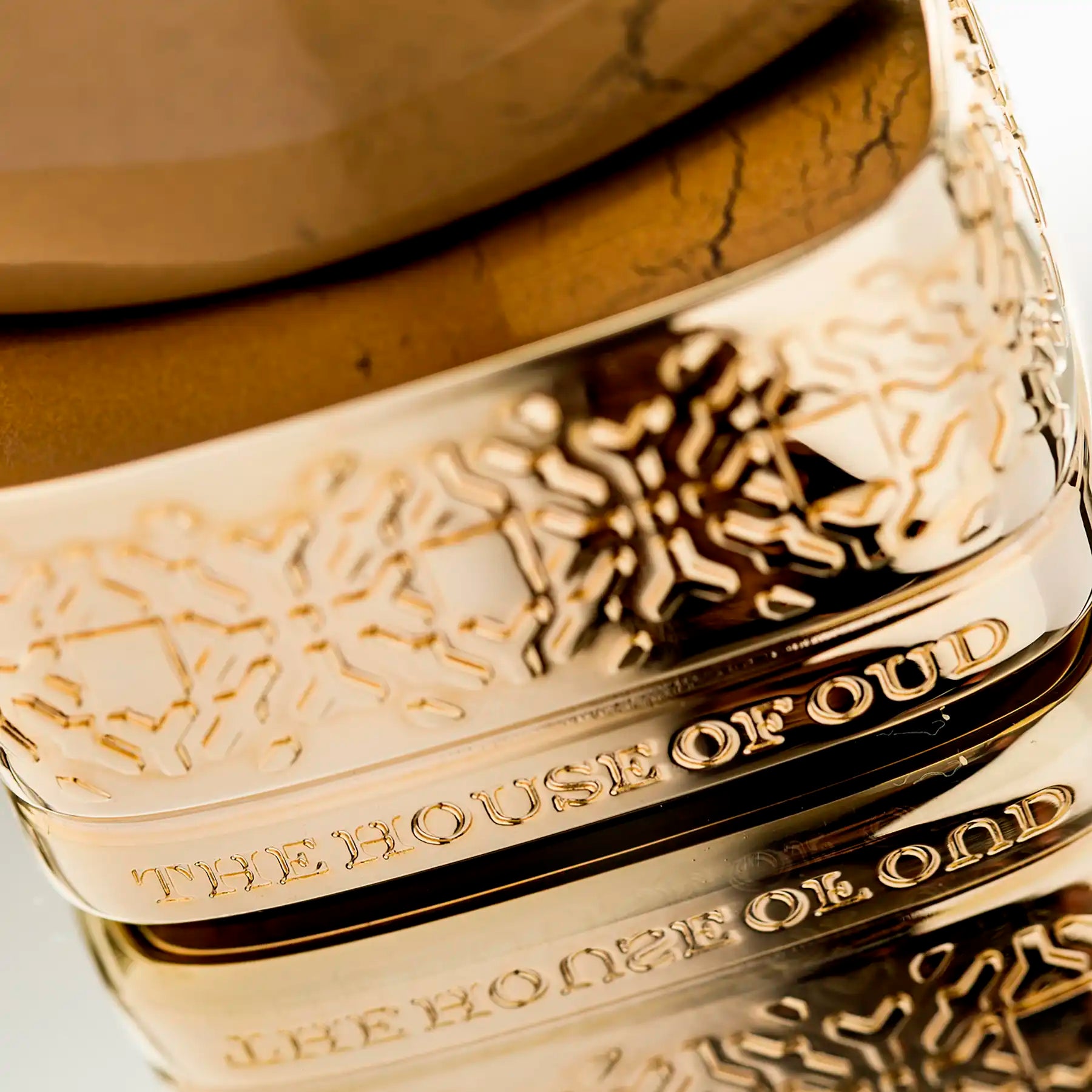 Close-up of Golden Powder Eau de Parfum bottle by The House of Oud, showing intricate gold base detailing