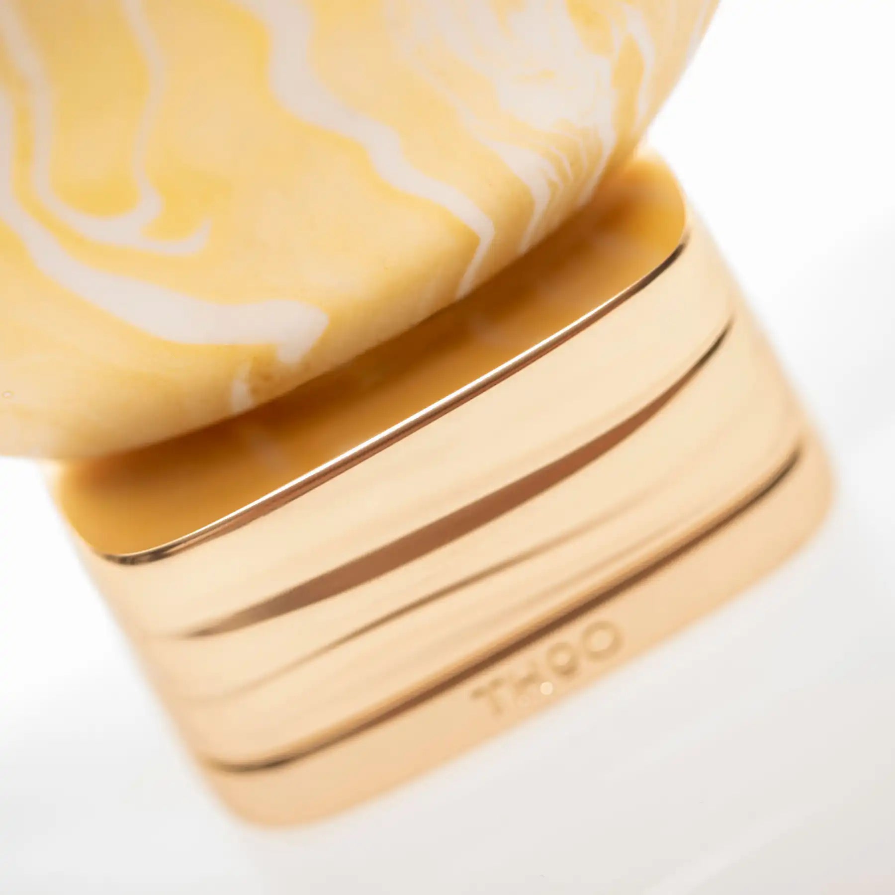 Close-up of What About Pop bottle by The House of Oud, highlighting the textured marbled pattern and gold base